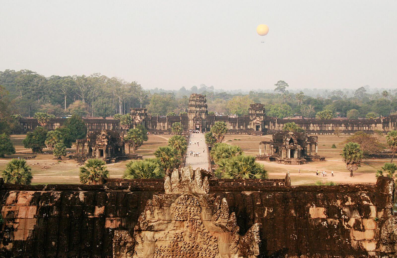 Aerial view of Angkor wat and a yellow hot air balloon